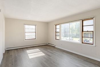 A large empty room with two windows.